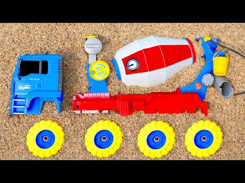 Find a large cement mixer truck, a long swerving truck, a train, a backhoe excavator, and a tanke...