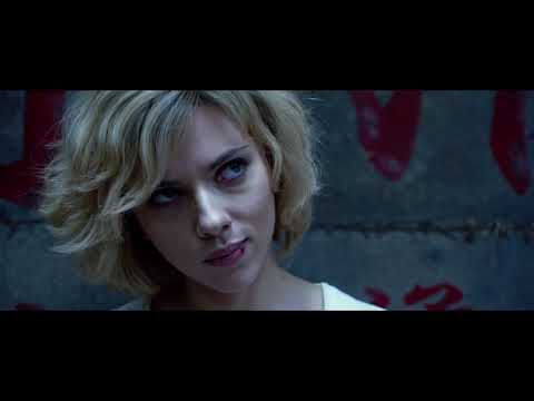 Lucy 2014 movie trailer frame with Scarlett Johansson walking through neon-lit Taipei street