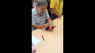 コカコーラのペットボトルにサインするジジェク