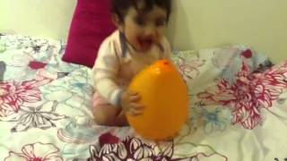 Laughing baby playing with balloon