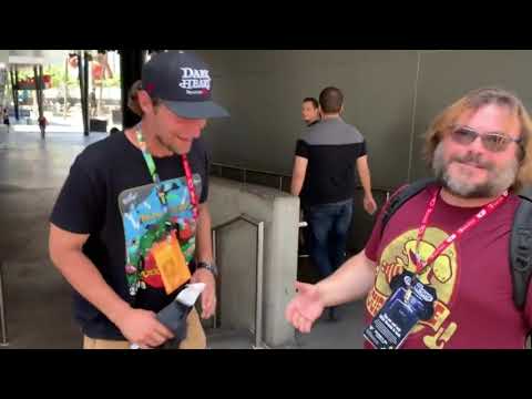 Jack Black catchs up with a fan wearing a Tenacious D tee shirt.