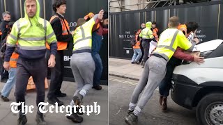 Angry workmen push Just Stop Oil protesters out of the road
