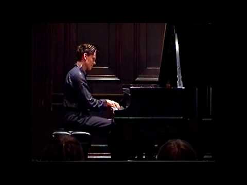 Brett Klaus performing Liszt’s Vallée d’Obermann in a dark navy shirt with gold stripes