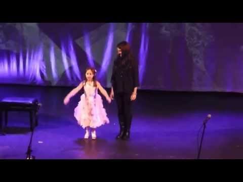 Lana performing on stage with Cara Braia singing Popular.