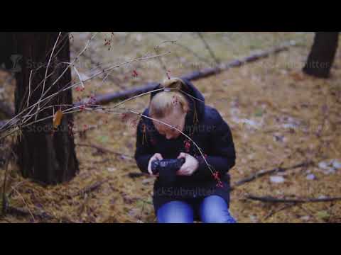 girl photographer takes pictures of the autumn nature in the forest. cinematic shot, slow motion