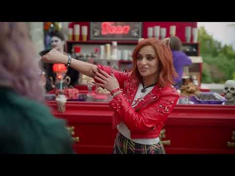 Monster High 2 official trailer frame: Clawdeen, Frankie, and Draculaura in neon-lit hallway