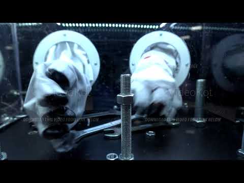 Closeup of man's hands in astronaut gloves trying to screw the nut with the help of key