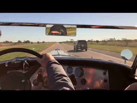 Model J Duesenberg passing modern traffic.