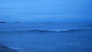 4K Sea Sounds: sunrise sky turns every shade of blue! Camera very close to the waves