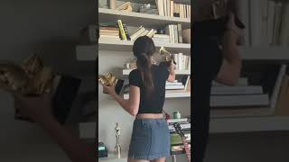 Olivia Rodrigo putting her grammys on her shelf