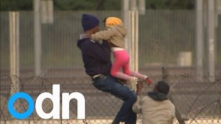 Young girl passes barbed wire while making the journey to Britain