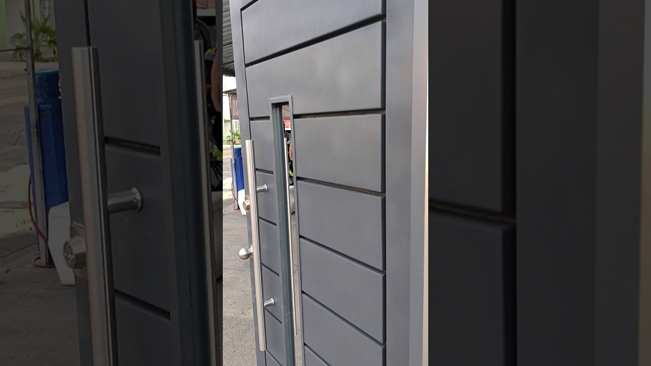 puerta de herrería con acabados en acero inoxidable y chapa residencial