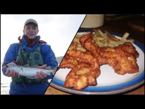 man holding fish and a plate of fish and chips