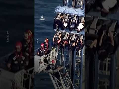 Firefighters work to free riders stuck atop a rollercoaster in Texas