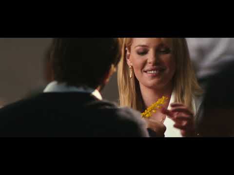 Trailer collage: airport lounges and cul-de-sac chases; the music toggles between postcard pop and caper stings