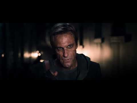 Trailer still: Adam framed by stained glass as embers fall and the choir tapers to a solo voice