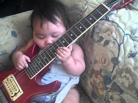 VIDEO - Lee-Way-Nit  Marlene Flores ( Yokuts-Hopi Indian) Playing Her Red Guitar At 5 Months Old