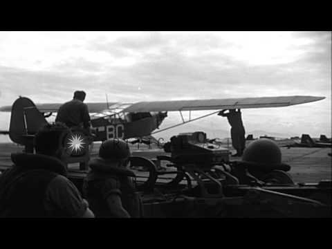 Cub planes take off from runway aboard LST (Landing Ship, Tank) during pre-invasi...HD Stock Footage