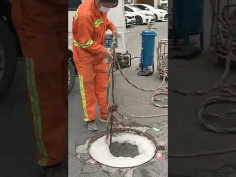 Diver unclogging street sewer