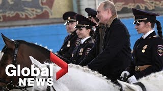 Vladimir Putin rides horse with female police offi