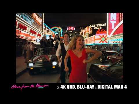 One from the Heart trailer still — neon Las Vegas backlot with lovers in silhouette, Tom Waits & Crystal Gayle score in mind