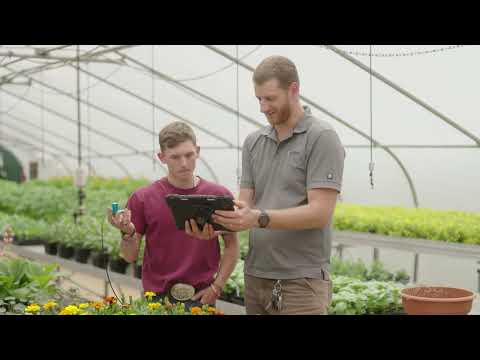 People working among plantings in a greenhouse, frame from SC Green TV