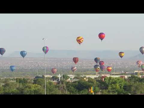 Angela watches balloons from hotel room