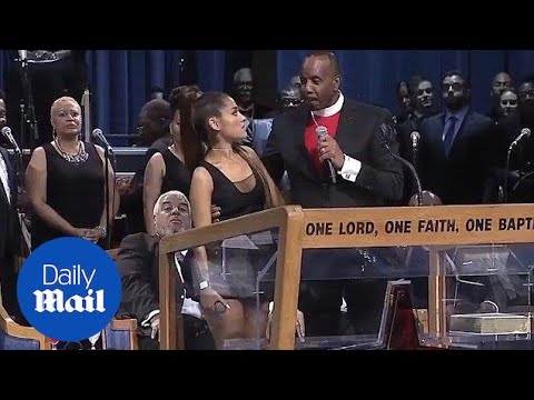 Bishop Charles Ellis holds Ariana Grande tight in awkward exchange