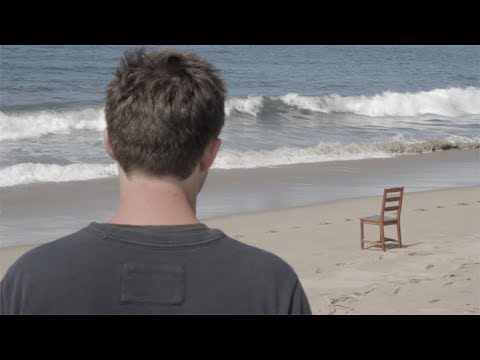 Two Men Consider Sharing A Chair At The Beach