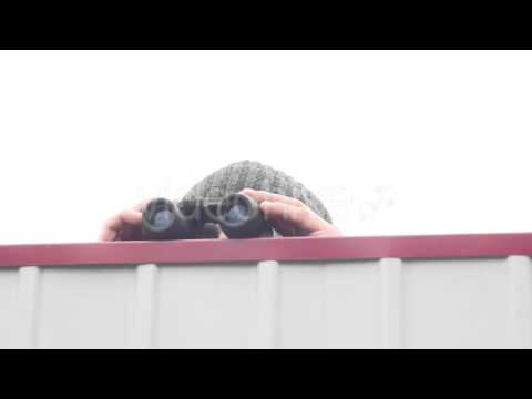 Man With Binoculars Spying Over the Fence