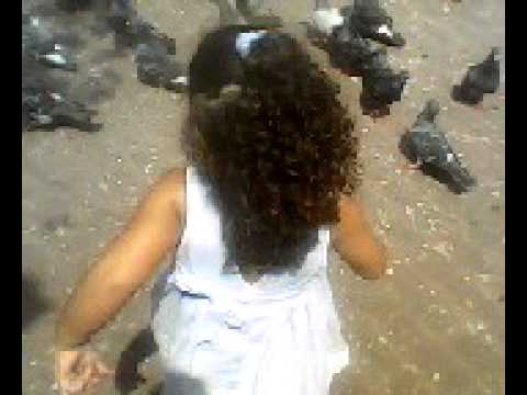 la niña que corretea a las palomas