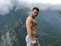 Handsome boy showing muscles in mountains