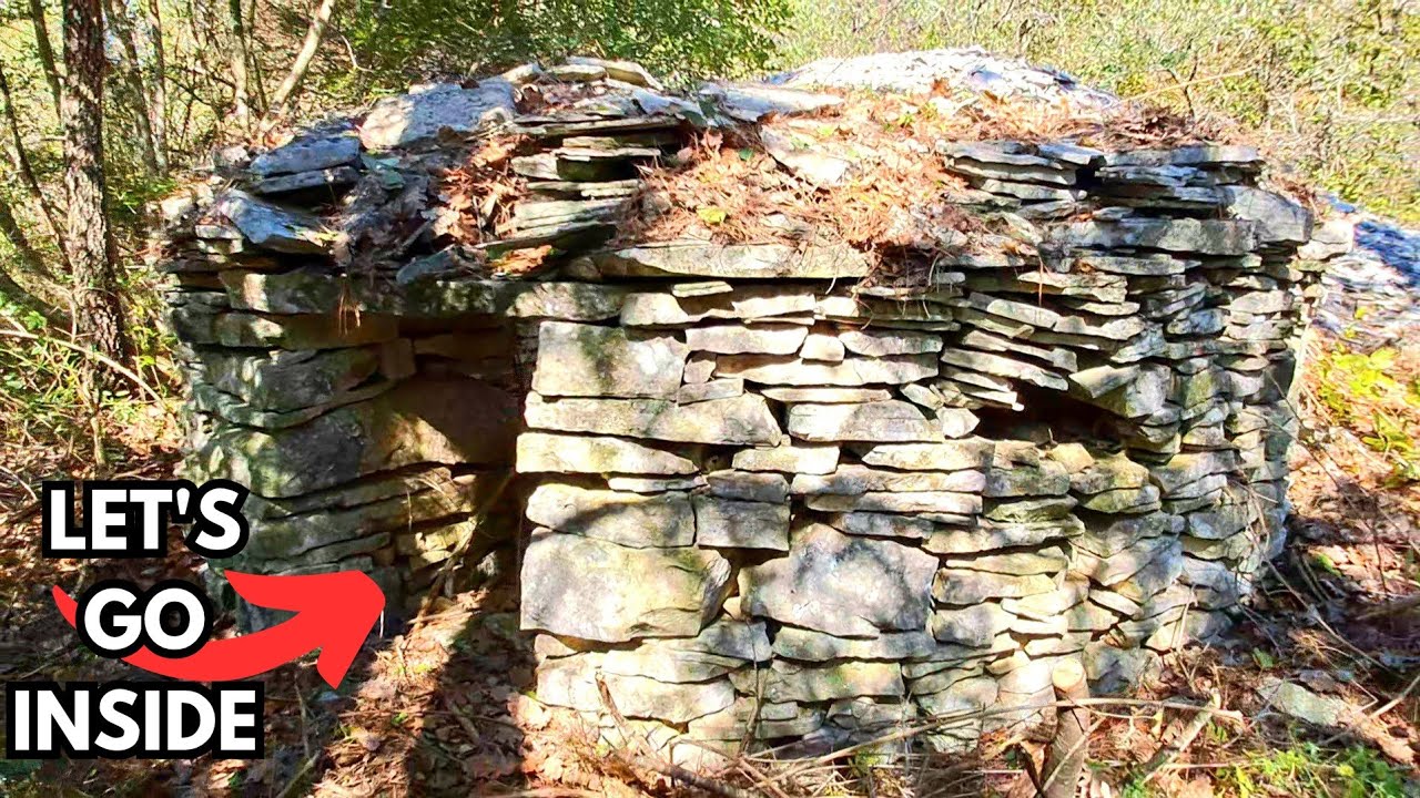 ABANDONED OLD STONE HUT with a SMALL ROCK MOUNTAIN BEHIND