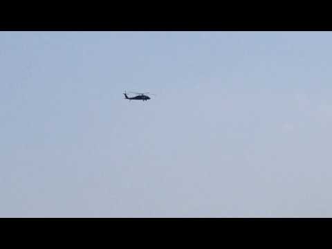 MILITARY HELICOPTER FLYING OVER BROOKLYN BRIDGE & EAST RIVER IN LOWER MANHATTAN AREA, NEW YORK CITY.
