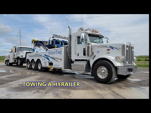 ROTATOR TOWING A LARGE HYRAILER TRUCK.