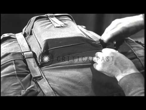 A ski trooper wears a rucksack and adjusts its straps in an equipment room in the...HD Stock Footage