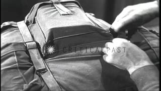 A ski trooper wears a rucksack and adjusts its straps in an equipment room in the...HD Stock Footage