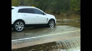 Car drives through low water crossing