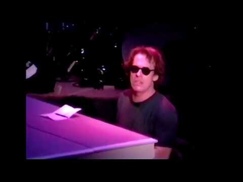 Lennon Broadway musical scene montage: ensemble silhouettes against peace-sign projections