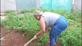 Marcia Nunes capinando o quintal de sua casa