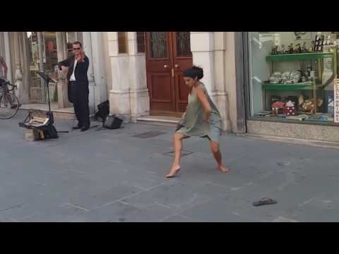 Straßenmusiker und Touristin die tanzt