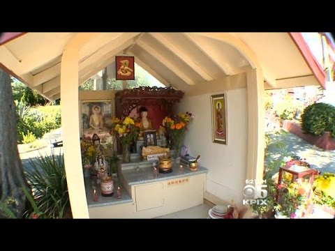 Why are Buddhist shrines often decorated with candles and flowers?