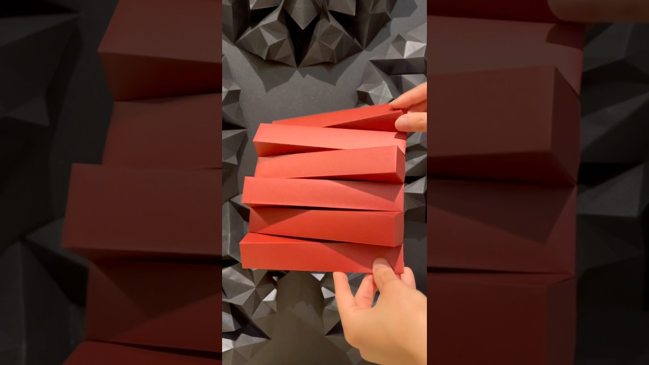 Folding metallic red paper into geometric forms. Origami; Alternate(Metallic Red)