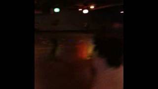 Man in Hooters shirt dancing on roller skates