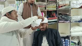 এক বক্তা আরেক বক্তাকে পাগড়ি পরিয়ে দিচ্ছে