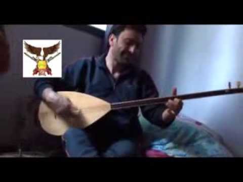 قائد لواء جبهة الأكراد علاء جبو يعزف على آلة البزق أثناء جلسة لمقاتلي اللواء