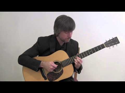 guy in suit playing acoustic guitar: width=
