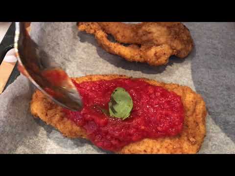 Cotoletta alla parmigiana, Italian schnitzel with tomato and mozzarella + basil.