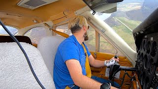 Cessna Cardinal landing at a hilltop airport and next to parked jets in Pittsburgh