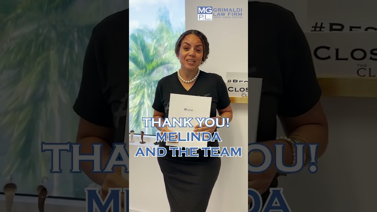 Client expressing gratitude to Grimaldi Law Firm, holding a document, with a backdrop featuring palm trees and firm branding, emphasizing estate planning services.
